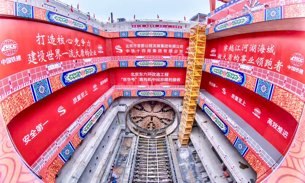北京东六环改造工程南起京哈高速立交，北至潞苑北大街，线路全长约16公里，其中盾构段长7.4公里，盾构隧道直径15.4米，最大埋深59米。首段掘进过程中，项目团队先后攻克11项技术难题，顺利穿越京哈铁路、北京城市副中心综合交通枢纽等30余处风险源，创造了单月进尺542米的掘进纪录，申报研发工法、专利等23项，首创超大直径同步双液注浆技术填补了国内空白，为同类型盾构施工积累了宝贵经验。图为“京华号”盾构机到达中间风井，顺利出洞。