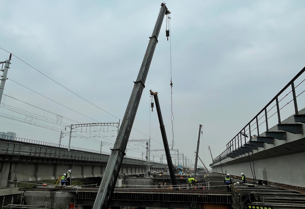 本次施工的成都南联络右线特大桥位于成都市三环路南三段至锦江大道之间，梁体全长89.9米，高2.5米，梁体重约2200吨，为全线重点工程。施工过程中，平移粱平移距离为22.29米，相当于在空中同时拖动1500辆小轿车进行移动。该平移粱施工同时创下了国内最大的连续变截面道岔梁横向平移施工记录，为同类型施工提供了经验。图为平移梁施工现场。
