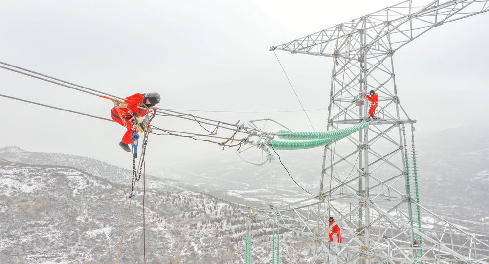2月13日，在山西送变电公司承建的山西寿阳明泰电厂、西上庄电厂点对网500千伏线路工程施工现场，施工人员开展雪后架线作业。