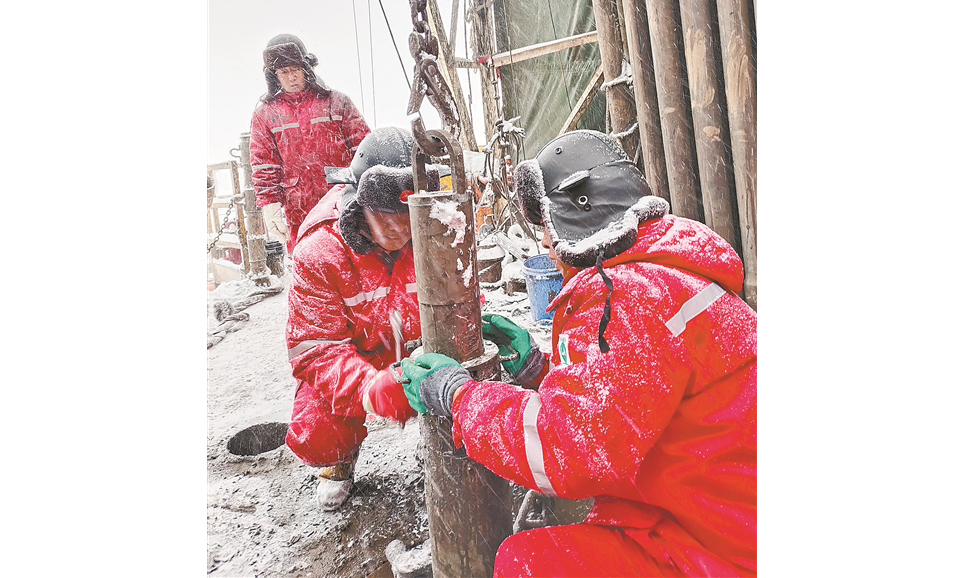 长城钻探工程院技术人员冒雪在大庆油区中浅层石油勘探项目双86井现场进行取芯作业。