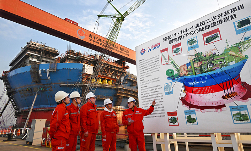 12月4日，工程技术人员在建造中的“海洋石油122”旁交流。新华社记者 李紫恒 摄