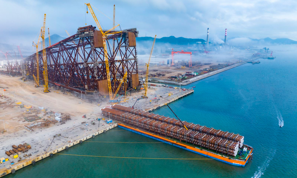 导管架钢桩是将导管架牢牢固定在海底的关键结构。“海基二号”导管架钢桩共有16根，每根直径约为2.7米，主桩长约170米，辅桩约为168米，钢桩总重约12500吨，是目前亚洲尺寸最大、重量最重的导管架钢桩。图为“海基二号”导管架钢桩完成装船。