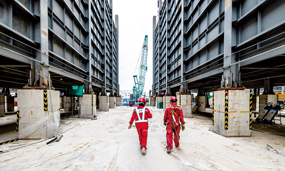 广西石化炼化一体化转型升级项目建设现场，安全监护员向即将进行高空作业的施工人员强调安全要求。