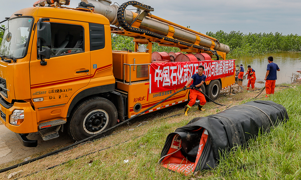 近日，湖南岳阳市华容县洞庭湖一线堤防决口完成封堵任务后，针对团洲垸内积水内涝严重情形，政府部门从各地调派排涝力量实施跨省区增援，执行积水排涝任务。中国石化各企业全力组织应急保障力量，国家危险化学品应急救援武汉石化队集结救援人员31人，出动龙吸水、泵浦车、水带敷设车等共10辆，于7月9日凌晨2时到达岳阳华容县，增援团洲垸内积水排涝抢险救援任务。截止至2024年7月18日6时，武汉石化队排水总时长为158.5小时，抽排水总量为70.20万立方米。付松 摄