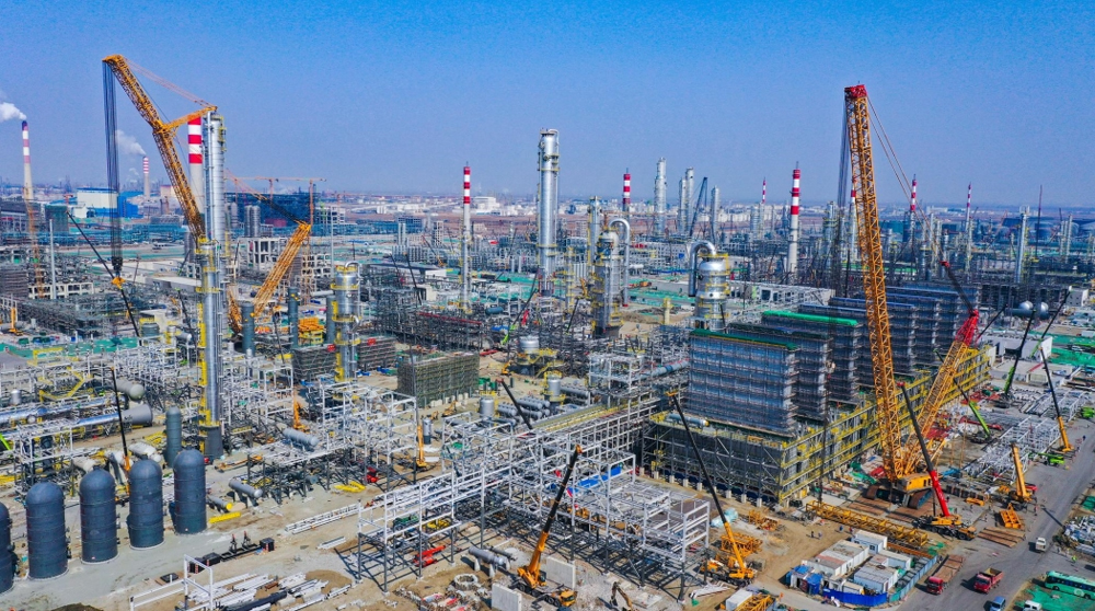 近日，兵器工业集团参建的华锦阿美精细化工及原料工程项目建设现场一片繁忙景象。塔吊伸展长臂，有序地吊运装着建材和设备，2万名建设者穿梭在各个作业面，机械的轰鸣声、建材的切割声、敲击金属的锤打声交织在8.97平方公里的工地上，奏响成一首激昂的建设交响曲。据了解，目前该项目总进度已接近60%，正向着竣工目标全力冲刺。