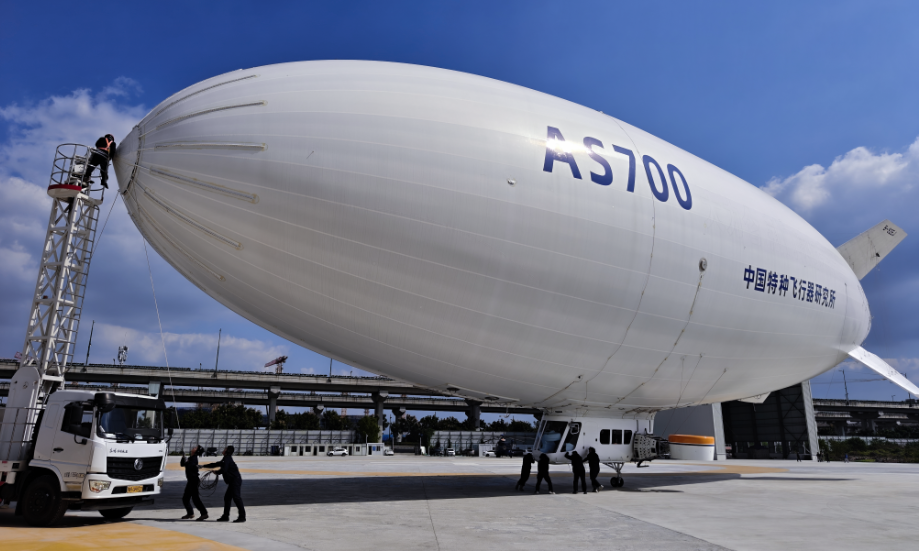 AS700载人飞艇由航空工业特飞所自主研制，是我国首个按适航规范研制、拥有完全自主知识产权的载人飞艇。它总长50米，最大航程700千米，可搭载10人。该飞艇凭借“低空慢飞、安全可靠”的特点，可在100～300米的最佳观景高度，让游客俯瞰江南水乡的风光。