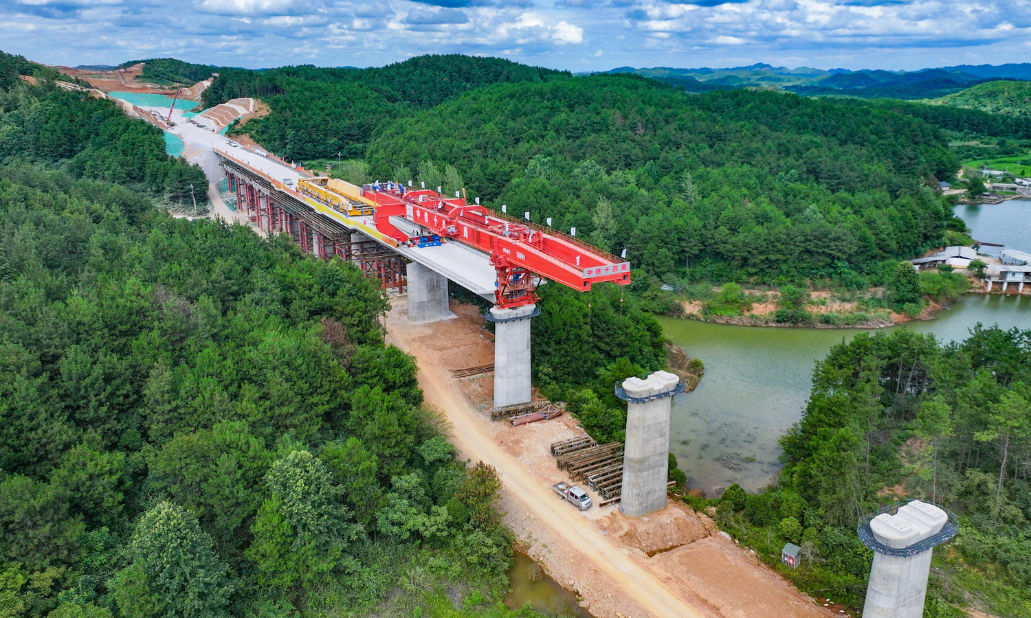 近日，在中国铁建所属中铁十四局铜吉铁路李家湾大桥施工现场，随着梁体精准落放在指定桥墩支座上，铜吉铁路全线首片预制箱梁架设顺利完成。这标志着铜吉铁路进入全线架梁施工阶段，为线路按期建成通车奠定坚实基础。