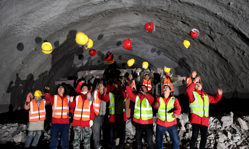 图为12月26日，工程建设者在施工现场庆祝隧道贯通。（新华社记者 朱祥 摄）