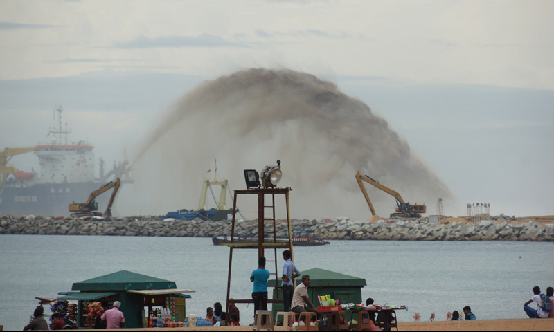 港口城项目是中斯两国在“一带一路”建设中务实对接的重点项目，由中国交通建设股份有限公司与斯里兰卡政府共同开发。图为2017年11月26日，在斯里兰卡科伦坡，市民遥看海面对岸港口城项目工地。（新华社记者 唐璐 摄）