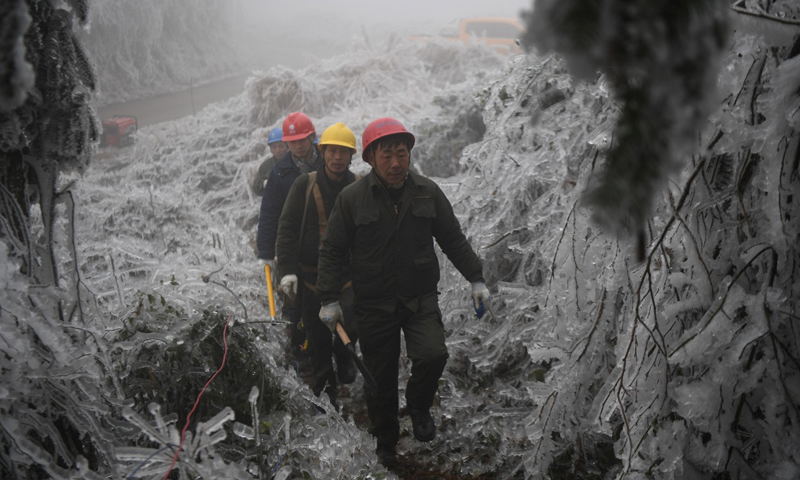 据了解，自2月8日0时起至2月20日16时，新化县共有142566户居民用电受到影响，经过181次故障抢修后，目前仍有5017户用户送电仍未恢复。图为2月20日，在新化县郭家村，电力工人在冰山中行走。（新华社记者 薛宇舸 摄）