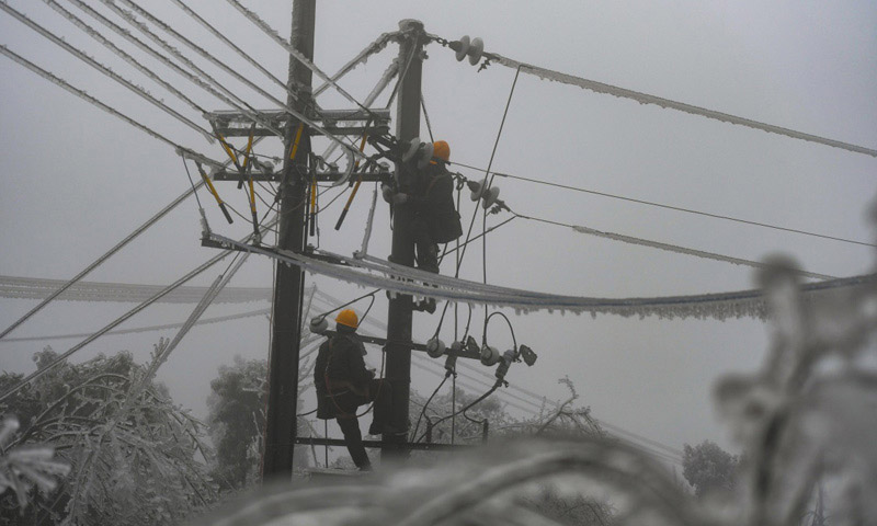 图为2月20日，电力工人黄通（右）和王放晖在新化县郭家村进行抢修作业。（新华社记者 薛宇舸 摄）