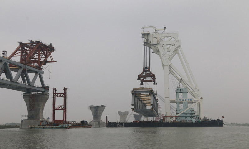 帕德玛大桥的建成将结束孟加拉国南部21个区与首都达卡之间居民摆渡往来的历史。帕德玛大桥将是连接中国及“泛亚铁路”的重要通道之一。图为2月20日，中国建造的万吨级中心架梁起重船“天一号”将总重超过3000吨的钢梁架设到桥墩上。新华社发（段永红 摄）