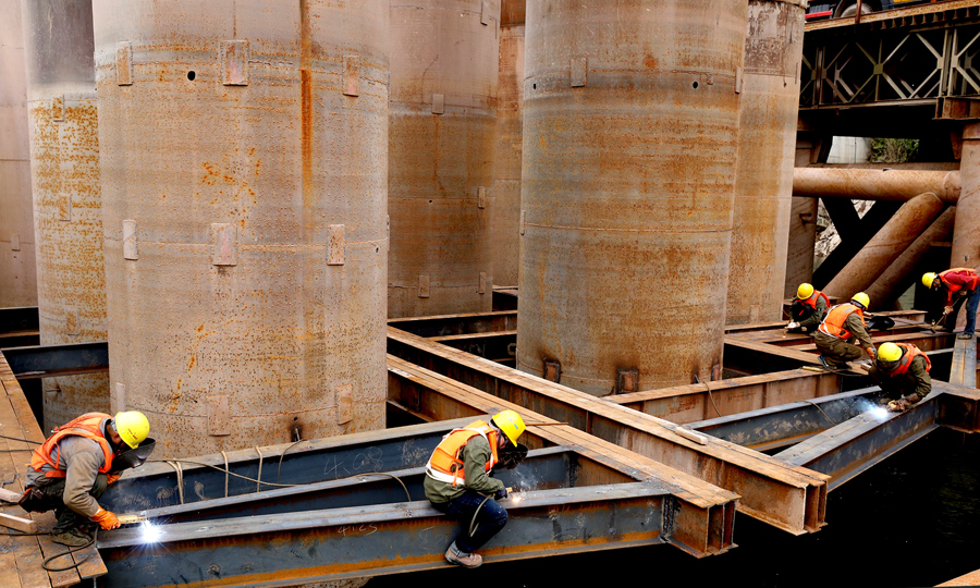 图为施工人员进行围堰底板龙骨拼装，为重达600吨的深水钢围堰下放做准备。（邓豪 摄）