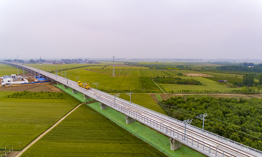 郑阜高铁全长277公里，设计时速350公里，是河南省“米”字形高铁网的组成部分。中铁十一局一公司郑阜项目部对路基、桥梁、交叉道路等重点段落、重点部位的绿化工程进行强化，做到施工一处、平整绿化一处，着力打造“四季常绿、三季有花”的绿色高铁。图为5月15日，建设中的郑阜铁路郑许特大桥完成两侧绿化施工。（金伟 摄）