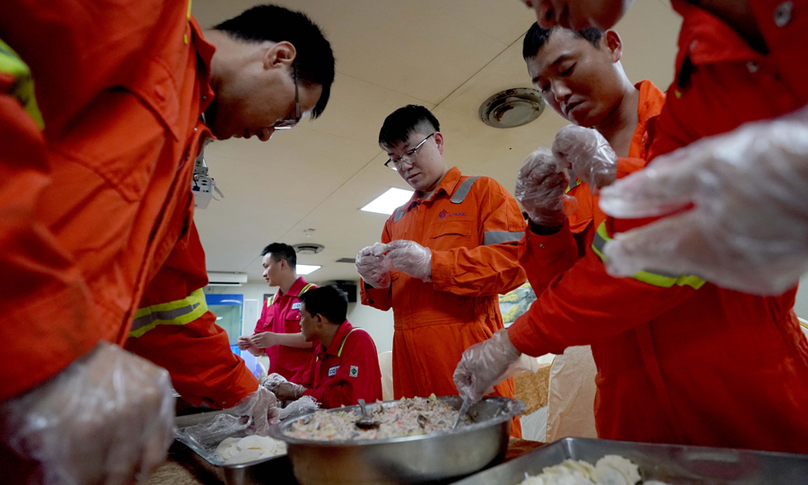 图为5月24日，员工们在工作之余到食堂帮厨，一起包饺子。（新华社记者 王毓国 摄）