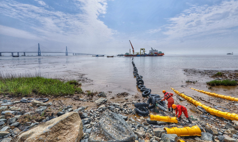 图为6月2日，最后一段海底电缆从海缆施工船上缓缓拖向舟山大鹏山岛的终端站。（新华社记者 徐昱 摄）