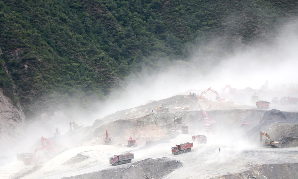 施工现场有时漫天风沙狂舞，洒水车洒水根本盖不住沙尘。图为6月12日拍摄的施工现场。（李明 摄）