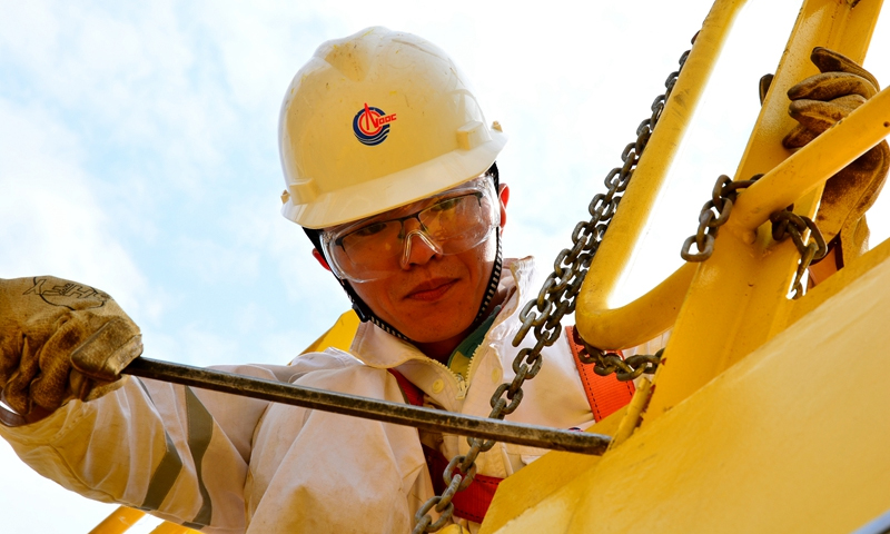 图为7月6日，在中国海油曹妃甸11-1/11-6油田综合调整项目CEPI组块总装作业现场，施工人员正在进行2台吊机的空中安装工作。他们精心作业准备，保障此次“空中攻坚”安全、顺利完成。