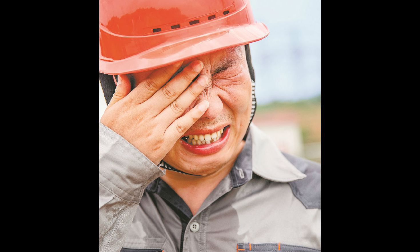 为保障特高压电网的正常运行，国家电网的工作人员冒着高温奋战在巡检一线。图为工作人员擦拭流进眼睛里的汗水。