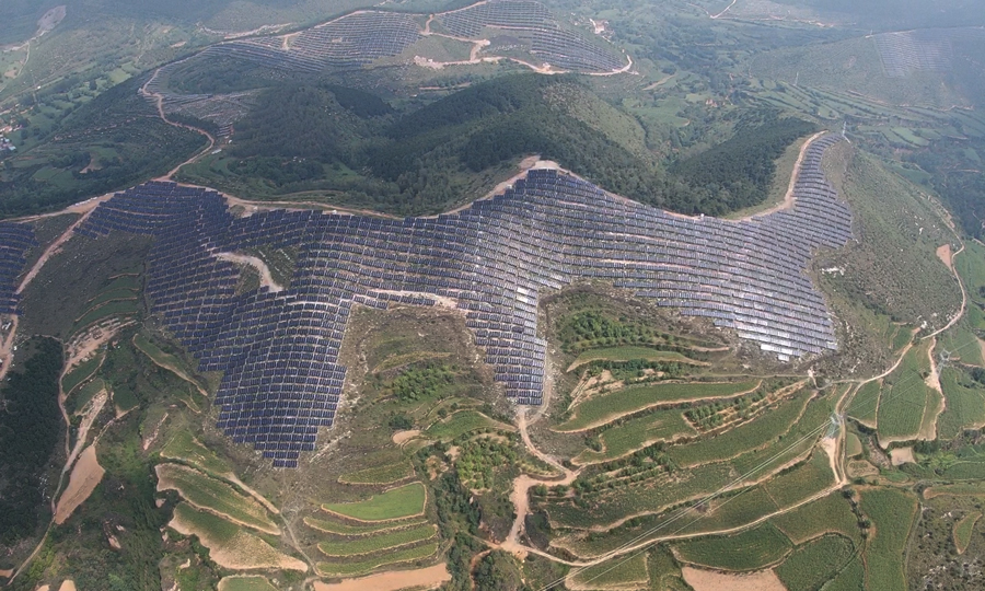 该基地为国家首批光伏发电技术领跑基地，也是山西省规模最大的光伏发电项目。山西电建协同参建黎城片区以来，充分发挥大型山地光伏项目施工经验，克服雨多风大气候恶劣等困难，采用样板先行等组织措施，创新自制施工器具，高效实现并网发电目标。图为8月2日，无人机航拍的山西长治光伏发电技术领跑基地。