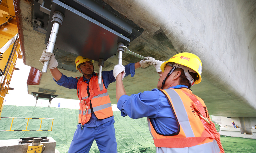 作为浙江省“一小时交通圈”和全省大通道建设的重点项目，杭绍台高铁连接了温（州）台（州）沿海城市群，是国家沿海铁路快速客运通道的组成部分和长三角地区重要的高铁新干线，预计2021年建成通车。图为工人们正在安装铁路桥梁球形型支座锚杆。（彭特 摄）