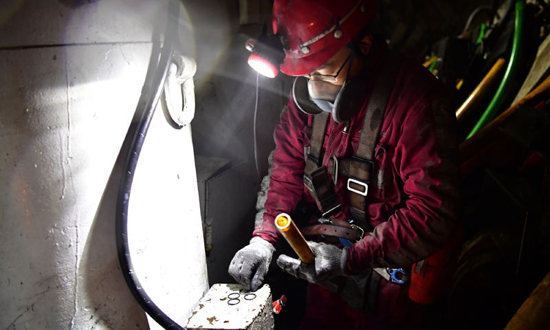 图为11月26日，在上湾煤矿12402综采面内，工作人员准备更换液压支架上的零部件密封圈。（新华社记者 邵瑞 摄）