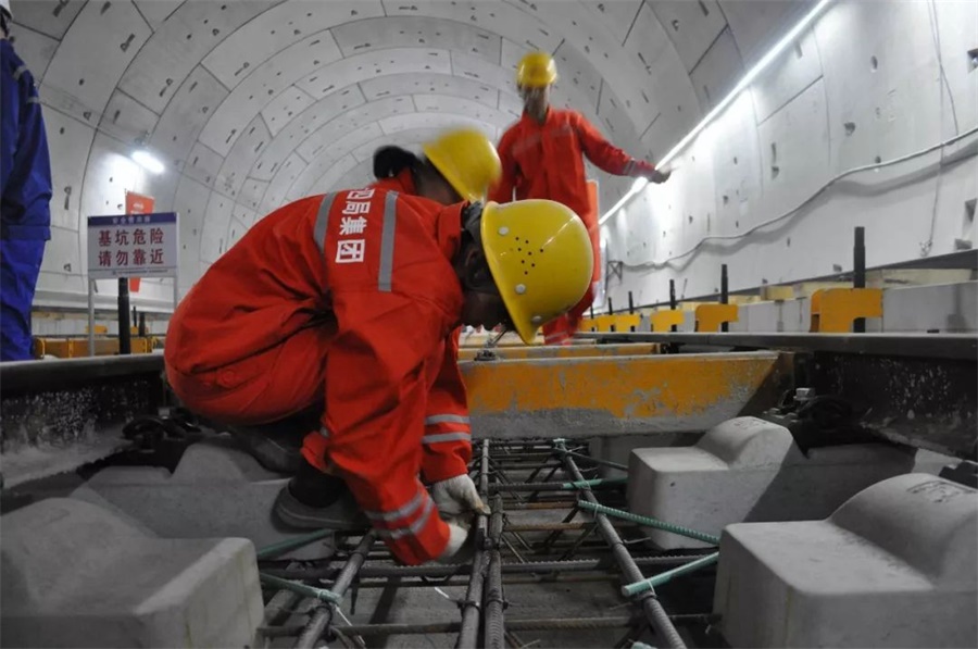 新中国成立以来，“国民经济大动脉”发展速度与国力同升。截至目前，中国铁路运营里程已达13.9万公里，其中高铁已达3.5万公里，高居世界第一。图为京张高铁无砟轨道施工，工人们正在洞内进行绑扎钢筋。