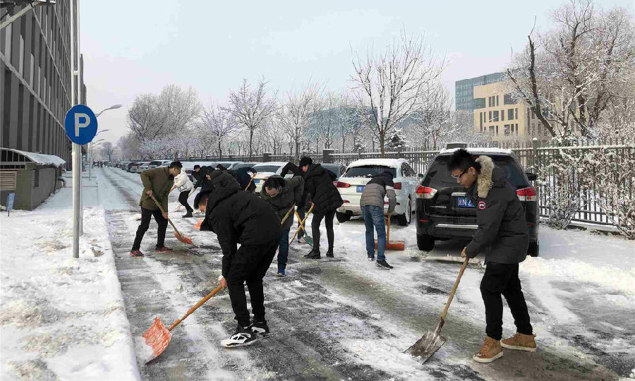 图为航天科技九院704所员工为北京永丰科技园区清雪，确保科研生产安全。（解笑然 摄） 