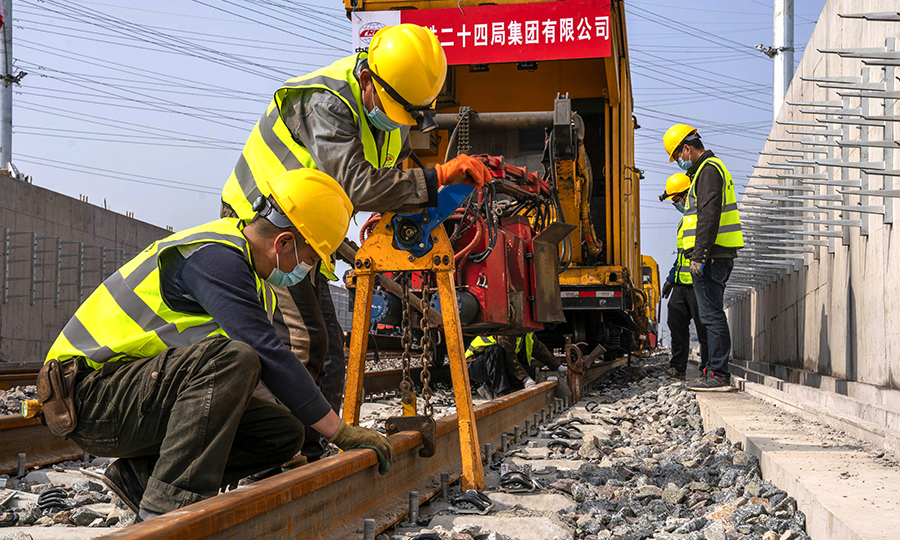 焊轨、磨轨、除锈、卸渣……近日，在国内首条具备最高等级全自动驾驶功能的轨道交通线——上海地铁15号线，工人们正在有序施工。图为上海地铁15号线铺轨B标工人师傅正在进行钢轨起到对位作业。