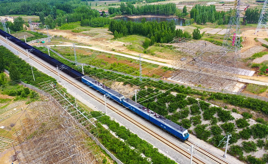 6月6日凌晨两点，220千伏城鹏线成功送电，标志着由中国铁建所属中铁十四局电气化公司承建的济莱高铁首条超高压线路迁改工程顺利完成。图为迁改施工中，在铁路既有线上空架设绝缘防护网。（范成涛 摄）