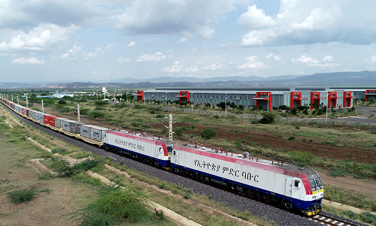 2020年上半年，亚吉铁路运量在疫情中逆势上扬，较2019年同期提升了51%，运营成效持续向好。图为亚吉铁路集装箱运输列车经过沿线德雷达瓦工业园。