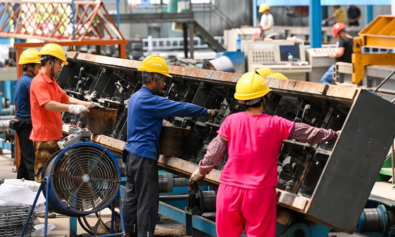 图为9月22日，工人在中国铁建华南建设有限公司南沙混凝土制品加工中心地铁轨枕生产线上清洁模具。（新华社记者 刘大伟 摄）