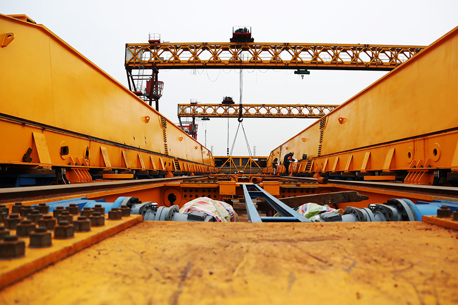 近年来，中国铁建所属中铁十一局汉江重工不断加大科技研发力度，先后设立了8个专业研究院，已成功研制出高铁提运架设备、起重设备、隧道施工配套设备、桥梁钢结构四大类装备产品，其中千吨级架桥一体机达到世界领先水平。图为国庆期间，工作人员加紧生产高铁千吨级运梁车。（徐云华 摄）