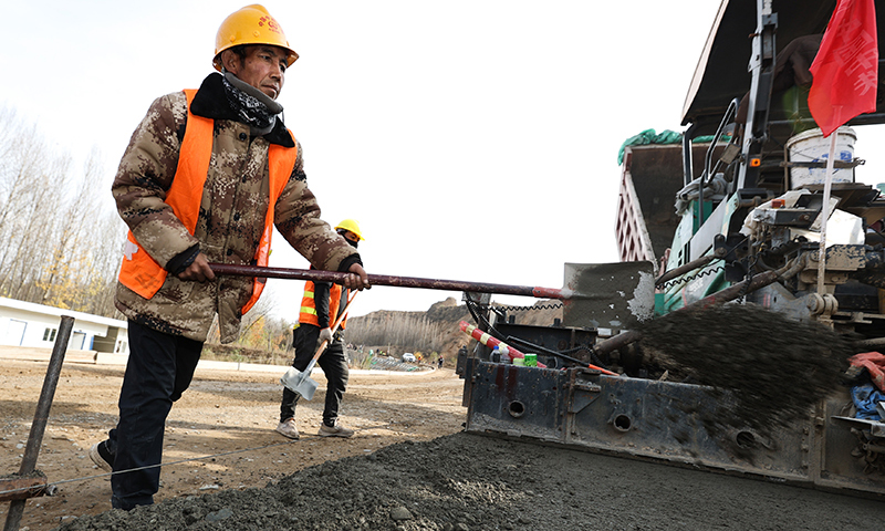 11月1日，在马康公路施工现场，施工人员在向路面补料。图为11月1日，在马康公路施工现场，施工人员在向路面补料。（新华社记者 吴刚 摄）