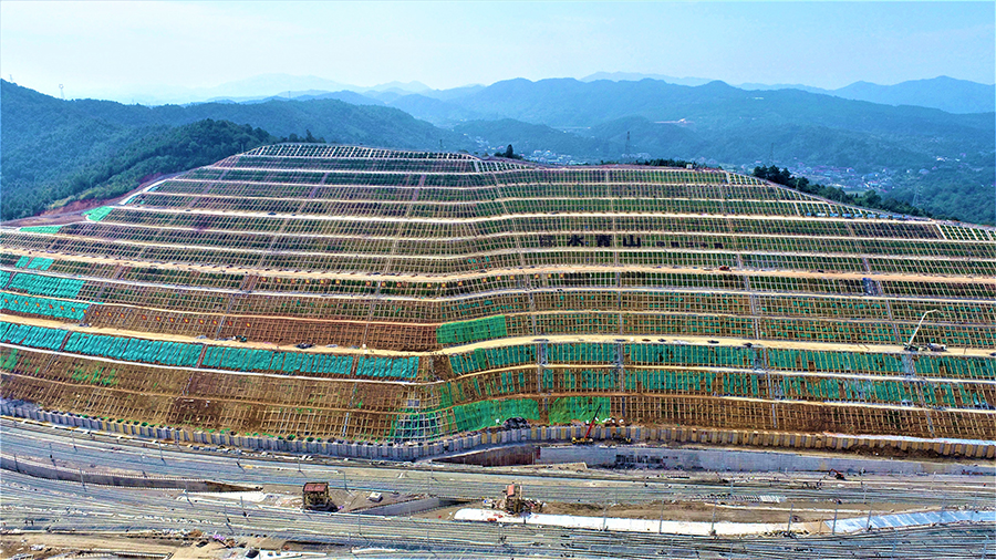 据悉，该边坡位于渝怀铁路增建二线怀化西编组站，其最大垂直高度124米，最大开挖宽度670米。该工程预计12月底达到开通条件。图为高边坡全貌。