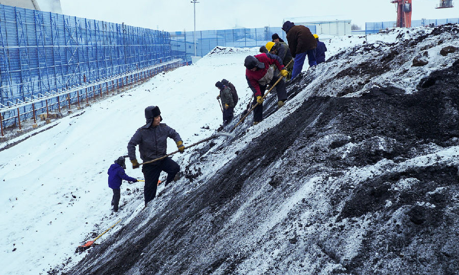 东北公司双鸭山电厂组织员工冒雪清理煤垛，杜绝积雪和冻煤块进入原煤斗。（隋轶英 摄）