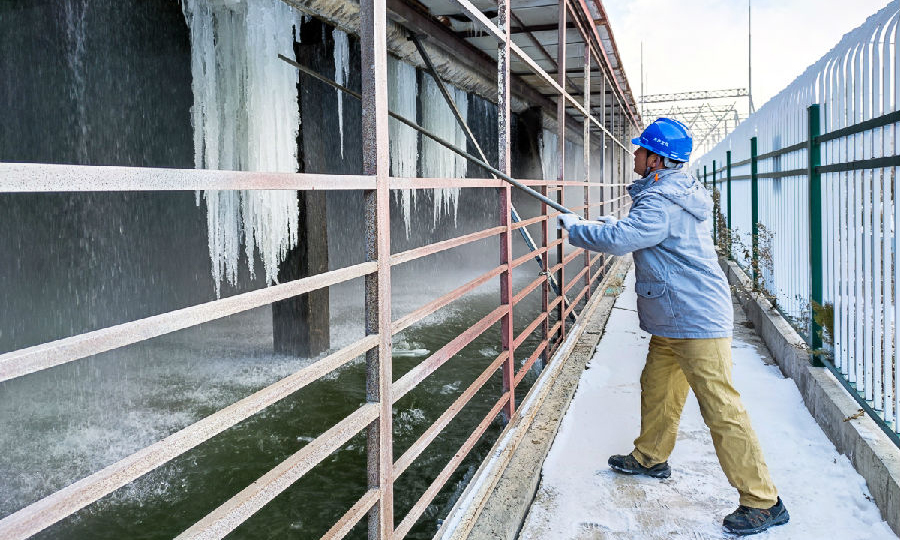 国华电力呼贝电厂维护部汽机压容班员工清理机力通风冷却塔内部挂冰。（冯奇 摄）