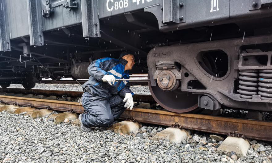 铁路装备包头分公司员工正在冒雪进行列车检修作业。（王嘉琦 摄）