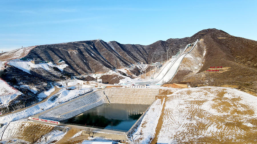 该基地是世界规划最大的跳台滑雪场馆群，并同步建设世界级别最高、国内唯一的高科技训练风洞，规划占地51.8公顷，计划分3期建设。其中一期项目包含赛道、水平风洞实验室、造雪系统、缆车系统、场地道路、市政工程6个子工程。图为蓄水池。