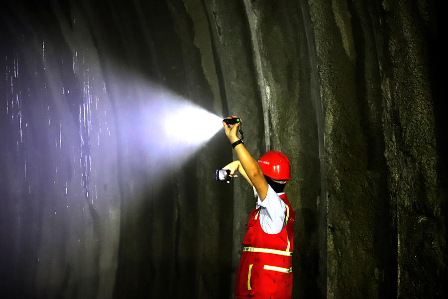 由中国铁建所属中铁十八局参建的关键控制性工程狮子山隧洞全长29.42公里，穿越8条地质断裂带，以及高烈度地震区和毒气地段，工程面临多项世界级技术挑战。图为技术人员查看隧道。