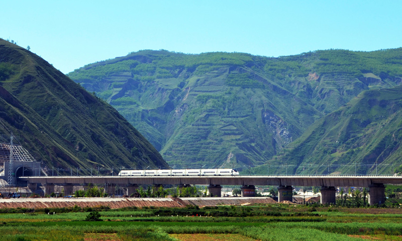 近年来，中国高铁继续保持快速发展步伐，“四纵四横”高铁网基本成形，技术成就赢得国际声誉，服务品质不断攀升。中国高铁已经成为一张见证时代发展的名片。2017年7月9日，一列高铁列车行驶在宝兰高铁甘肃天水段南河川大桥上（武龙 摄）。