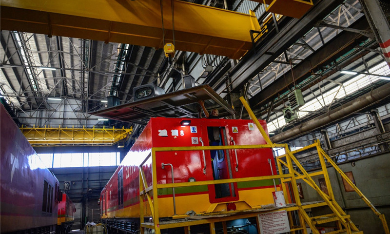 这是7月27日，在南非比勒陀利亚南非运输集团工厂的组装车间，一名当地技术人员操作行车将一块顶盖安放在机车上。（新华社记者 翟健岚 摄）