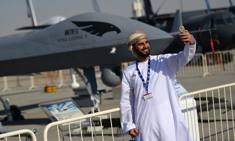 11月13日，在阿联酋迪拜航展上，一名参观者在“翼龙”无人机全尺寸模型前自拍。（新华社记者 赵丁喆 摄）