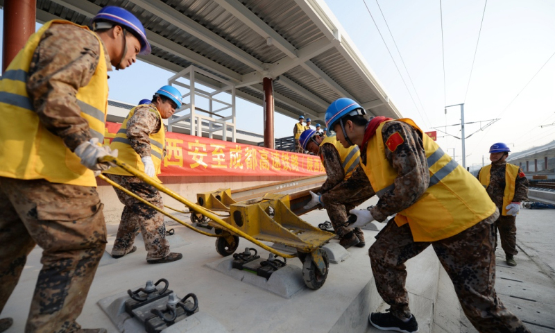 2月28日，施工人员在西成高铁陕西段宁强南站进行铺轨作业。（李一博 摄）