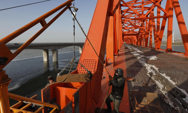 京张高铁官厅水库特大桥拱型八孔钢桁梁最后一孔在落梁施工中。（新华社记者 杨世尧 摄）