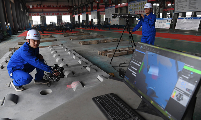 2018年1月22日，王伟（左）用激光扫描检板系统在对CRTSⅢ型先张法轨道板进行3D扫描检测。（新华社记者 宋振平 摄）