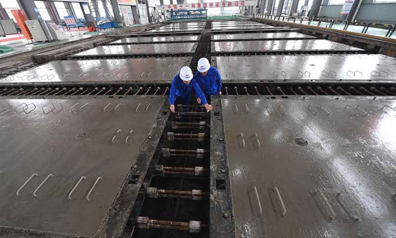 2018年1月22日，中铁十一局桥梁公司江西丰城制板场职工在CRTSⅢ型先张法轨道板的预制中进行质量检测。（新华社记者 宋振平 摄）