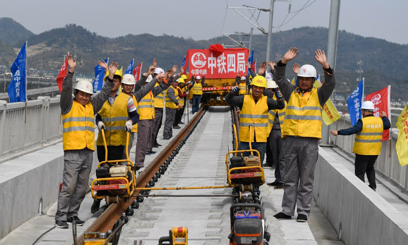 3月12日，完成铺轨作业的中铁四局施工技术人员庆祝杭黄铁路铺轨全线贯通。（新华社记者 黄宗治 摄）