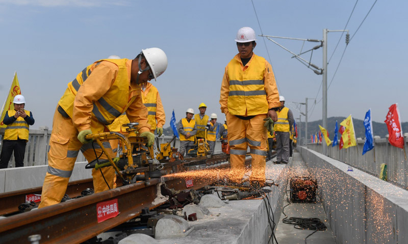 3月12日，中铁四局施工技术人员在传芳特大桥上进行杭黄铁路的最后一对轨头焊接和打磨作业。（新华社记者 黄宗治 摄）