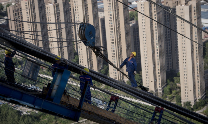6月25日，工人在杨泗港长江大桥引桥部分架设主缆。（新华社记者 肖艺九 摄）